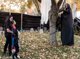 thre kids and tall persob in robbed death costume.