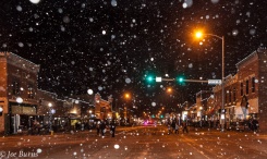 Snow falling on downtown street scene