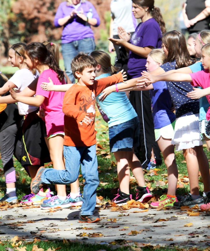Classmates greet fourth grader Connor Mahaffey as he runs toward the finish.