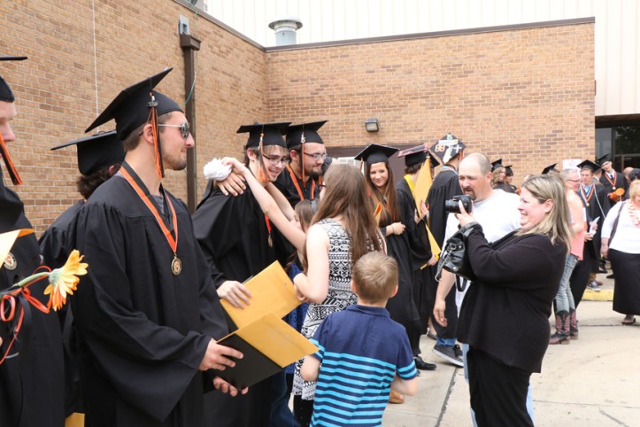 Graduates receive congratulations from family and friends following graduation ceremony. 
