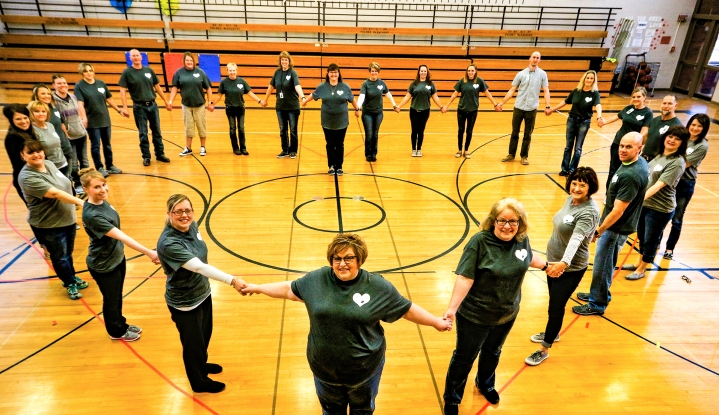 Arbor Park Intermediate School Facultyand staff stand in the shape of a heart in the school's gym. The educators are wearing T-shirts in honor or reading teacher Kris Burns, who died suddenly of heart failure in September. The teachers purchased the T-shirts or made donations which will be given to the American Heart Association in Burn's name.