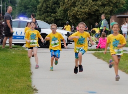 Runners from left: Annaliese Collins, Gabe Aten, Colton Scheer and Madelyn Kuhr sprint down Wilbur Street on the last leg of the Blair Kids Triathlon on Saturday.